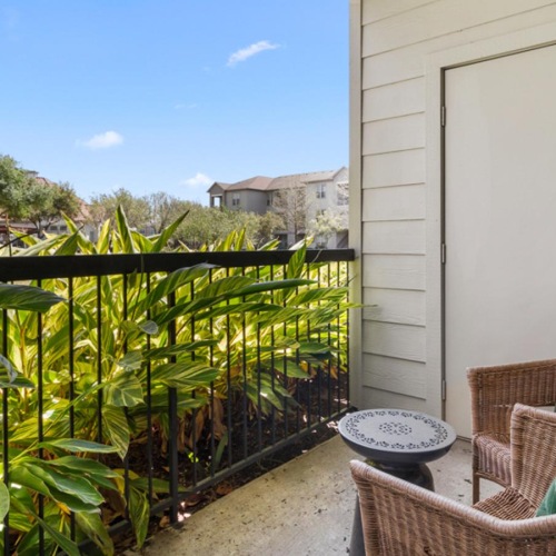 Spacious balconies a patio with a chairs and a small table